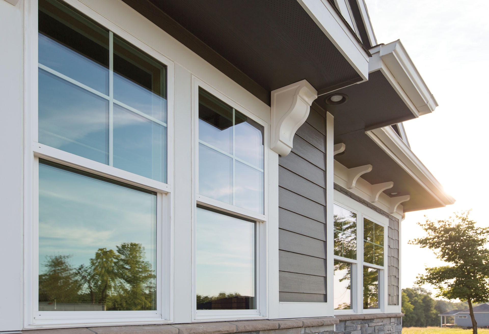 A set of two double-hung windows on a home with gray siding.